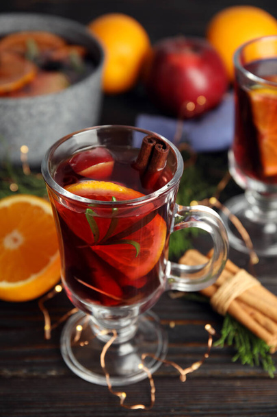 Tasty mulled wine with spices on wooden table - Foto, afbeelding