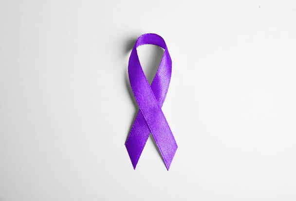 Purple ribbon on white background, top view. Domestic violence awareness - Fotó, kép