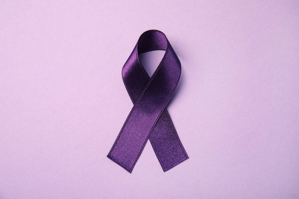 Purple ribbon on pink background, top view. Domestic violence awareness - Foto, immagini