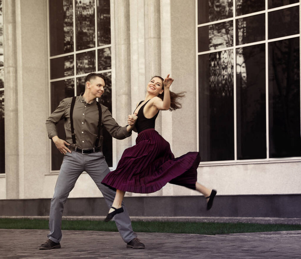 Beautiful young couple practicing dance moves on city street - Foto, Imagen