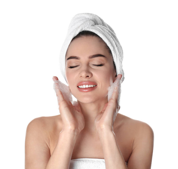 Jovem mulher lavar rosto com sabão no fundo branco
 - Foto, Imagem