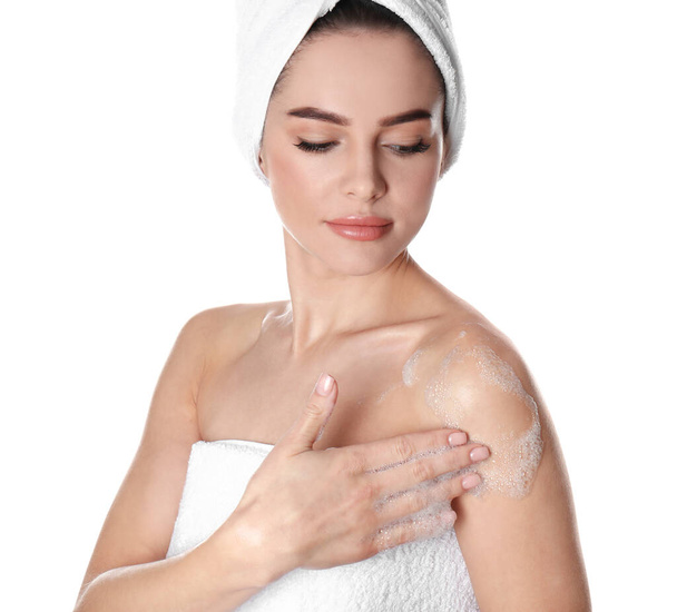 Mujer joven lavando cuerpo con jabón sobre fondo blanco
 - Foto, imagen