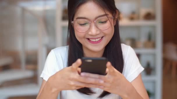 Freelance Asian women using mobile phone at office. Young Japanese Asia Girl using smartphone checking social media on the internet on the table at workplace concept. - Footage, Video
