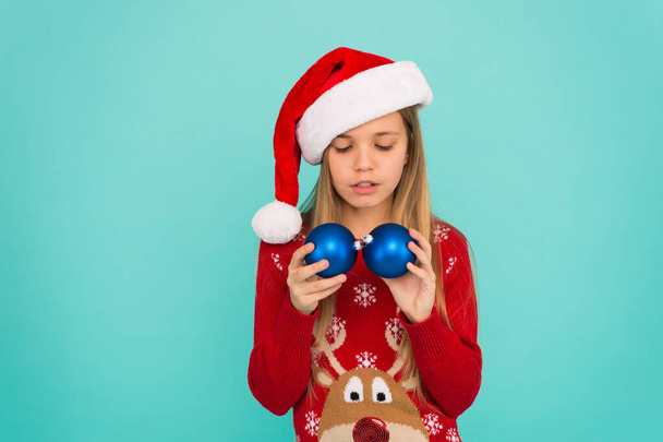 Let kid decorate christmas tree. Favorite part decorating. Add more decorations. Getting child involved decorating. Decorating christmas tree. Girl smiling face hold balls ornaments blue background - Foto, Imagen