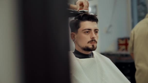 Friseur gibt einem jungen Mann in einem Friseursalon eine Frisur - Filmmaterial, Video