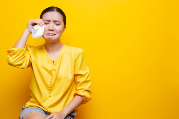 Mujer triste llorando y secándose las lágrimas con papel de seda
 - Foto, Imagen