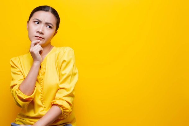 Woman feel confused isolated over yellow background - Foto, afbeelding
