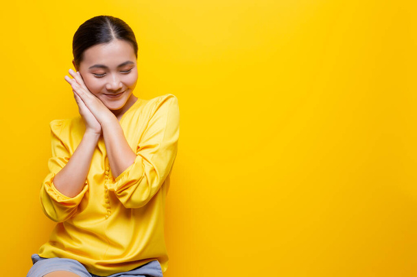 Mujer se siente tímido de pie aislado sobre fondo amarillo
 - Foto, Imagen