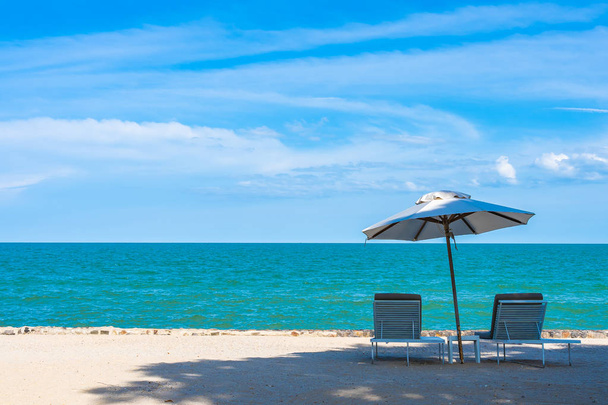 Belo guarda-chuva e cadeira em torno da praia mar oceano com sk azul
 - Foto, Imagem