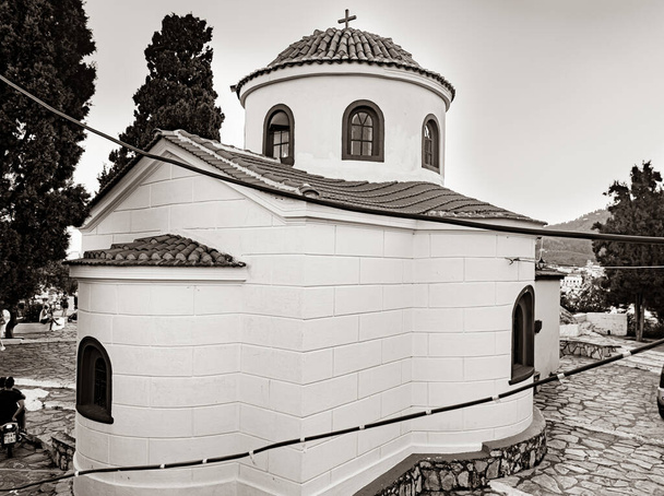 Iglesia típica de la isla griega encalada en la cima de la colina
 - Foto, imagen