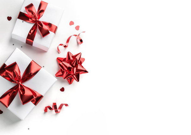 Coffrets cadeaux de Noël avec ruban rouge, étincelles, confettis et décoration sur fond blanc. Noël et bonne année de vacances. Couché plat, vue du dessus - Photo, image