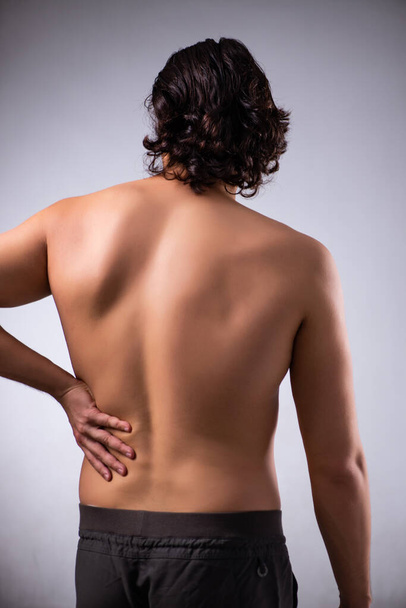 Mann leidet an Rückenschmerzen in grau - Foto, Bild