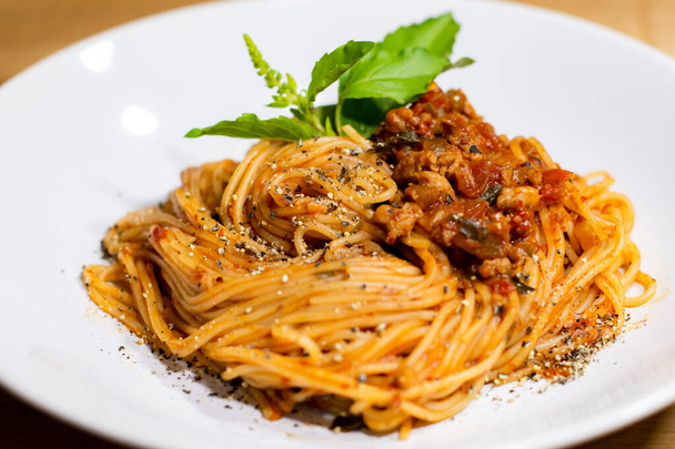 Spaghetti mit Schweinekoteletts und Tomatensauce in weißer Schale. - Foto, Bild