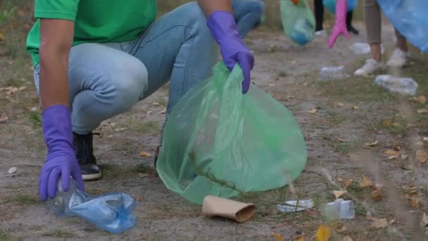 Volunteer smiling at camera while picking up trash - Footage, Video