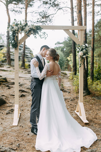 Beautiful couple at sunset in the Park. Wedding ceremony with arch in the forest.  - Photo, image