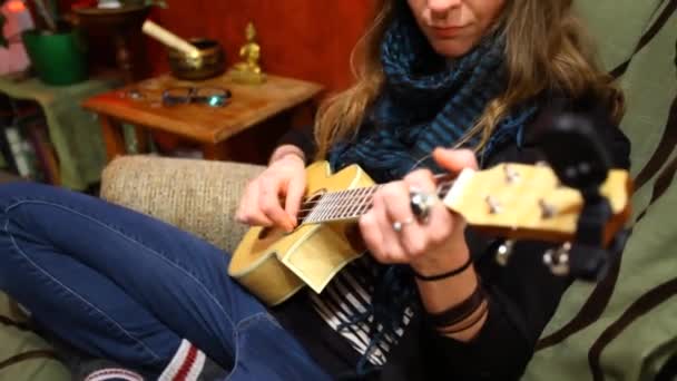 Lány játszik ukulele a nappaliban.  - Felvétel, videó