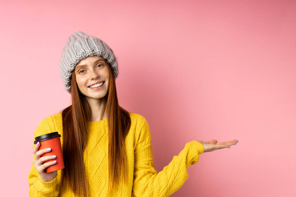 Redhead woman holding disposable cup of coffee - Φωτογραφία, εικόνα