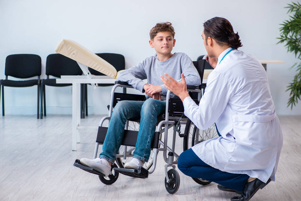 若い男性医師小児科医と車椅子の少年 - 写真・画像