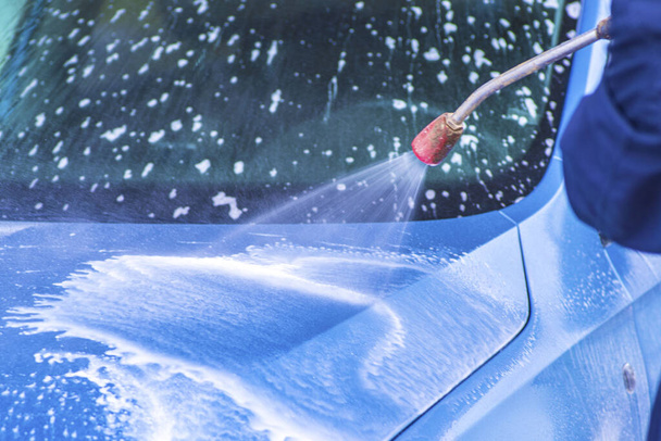 Kézi autómosó, nagynyomású vízzel, autómosó kívül. Takarítás autó használata nagynyomású víz. - Fotó, kép