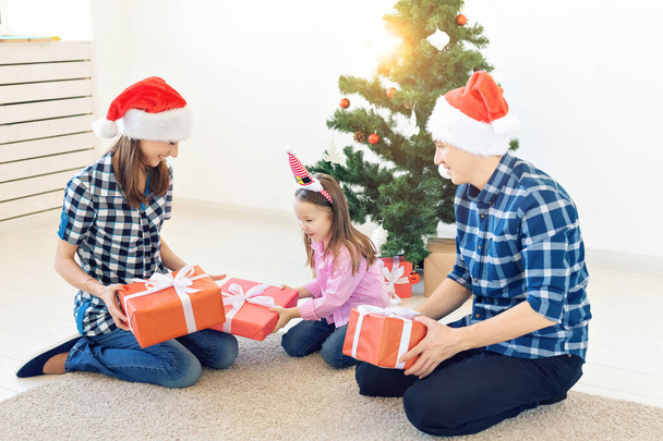 Urlaub und Geschenke-Konzept - Porträt einer glücklichen Familie, die zu Weihnachten Geschenke öffnet - Foto, Bild
