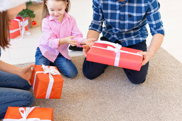 Holidays and presents concept - Close-up of family opening gifts at Christmas time - Foto, imagen
