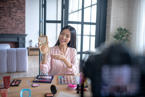 Blogger showing her favorite powder while making video - Photo, Image