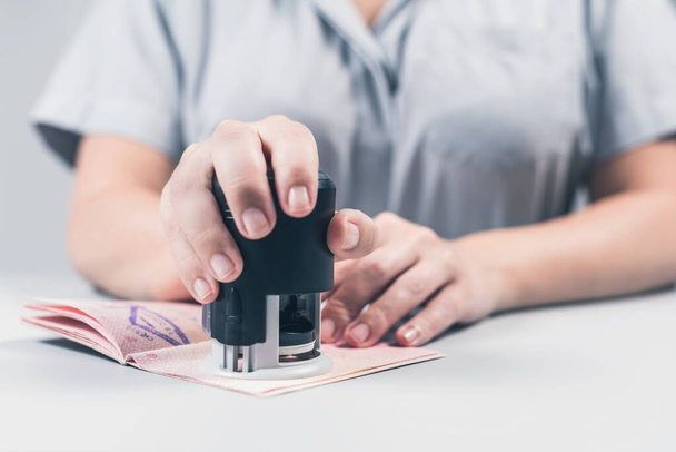Immigration and passport control at the airport. woman border control officer puts a stamp in the passport. Concept - Photo, image