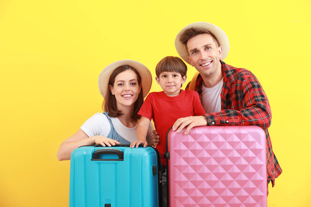 Happy family with luggage on color background - 写真・画像