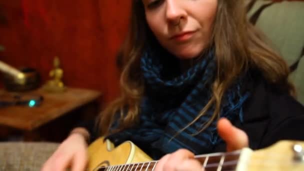 Lány játszik ukulele a nappaliban.  - Felvétel, videó