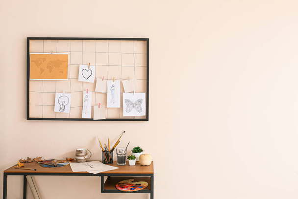 Comfortable workplace with mood board near light wall - Фото, изображение