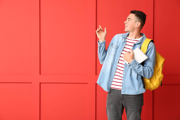 Cool teenage schoolboy pointing at something on color background - Photo, Image