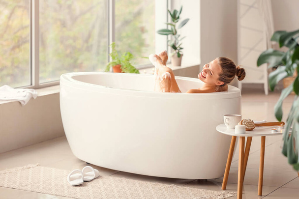 Beautiful young woman taking bath at home - Fotó, kép
