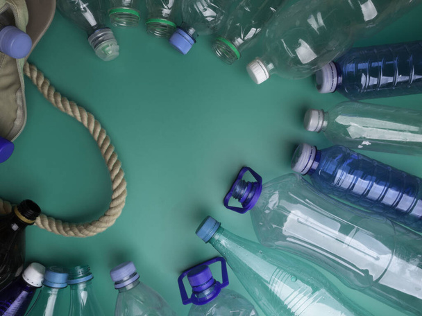 zár egy szemetes zsák üres műanyag palackok zöld háttér, műanyag palack szemetet újrahasznosítási koncepció újrafelhasználás - Fotó, kép