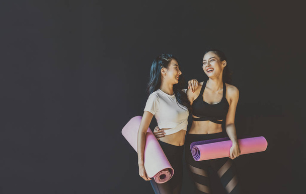 Paar sportieve Aziatische vrouwen staan en praten met vrolijke bewegingen, dragen van sportkleding BH en broeken mode, houding positie, sport club gemeenschap, sport en gezondheidszorg concept - Foto, afbeelding