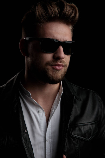 gorgeous casual man wearing sunglasses and looking away - Foto, Bild