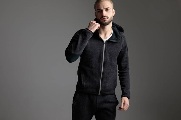 casual man wearing tracksuit standing with one fist up - Photo, Image