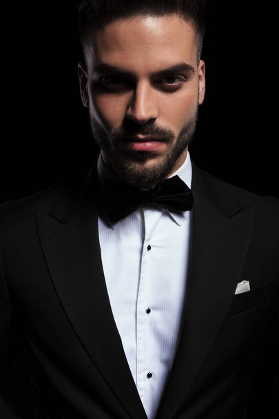 gorgeous businessman wearing black tuxedo staring at camera  - Foto, imagen