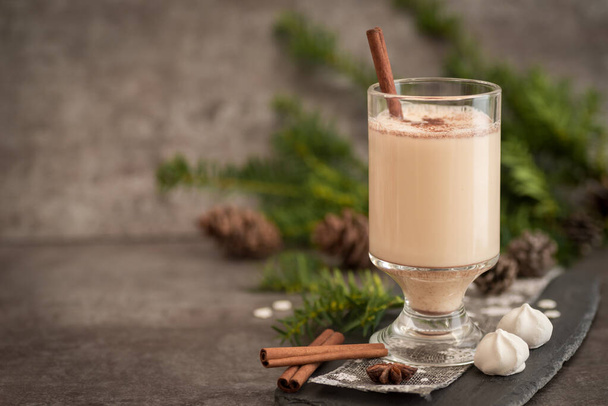 Eggnog in glass cups with a delicate foam, spices and a cinnamon stick - Valokuva, kuva
