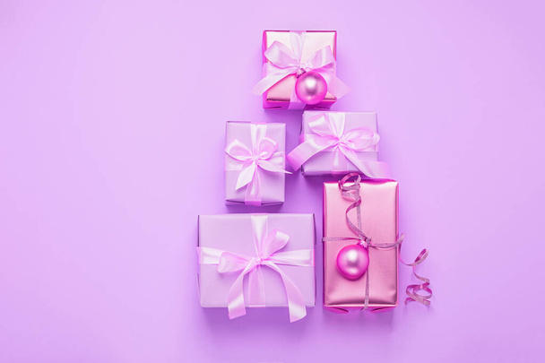 Boże Narodzenie twórcze pudełka upominkowe z błyszczącymi kulkami na pastelowym fioletowym tle różowy. Uroczysta koncepcja minimalizmu. - Zdjęcie, obraz