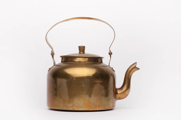 Old brass teapot on the white background - Foto, imagen