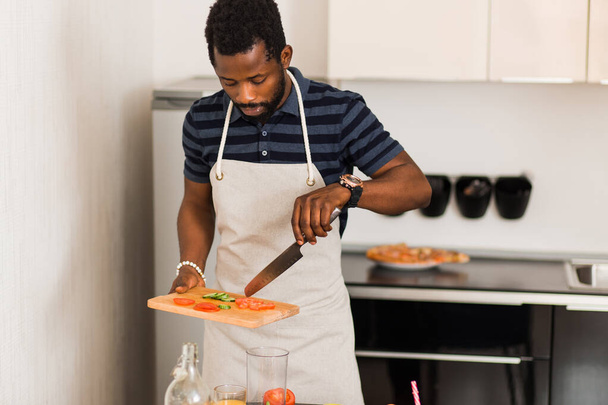 African man preparing healthy food at home in kitchen - Fotografie, Obrázek
