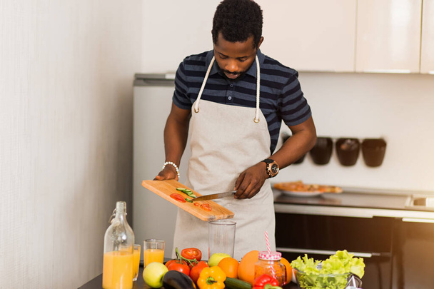 African man preparing healthy food at home in kitchen - Фото, зображення