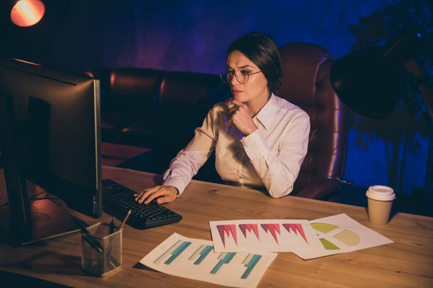 Portrait of nice attractive stylish chic concentrated lady top executive manager company agency owner preparing report plan strategy investment ratio result at night dark work place station - Photo, Image