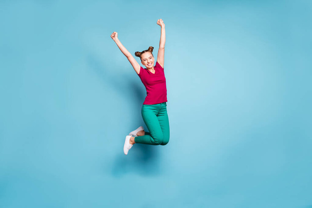 Full length body size photo of cheerful white brunette haired girlfriend wearing pants trousers green rejoicing in winning competitions isolated over pastel blue color background - Foto, imagen