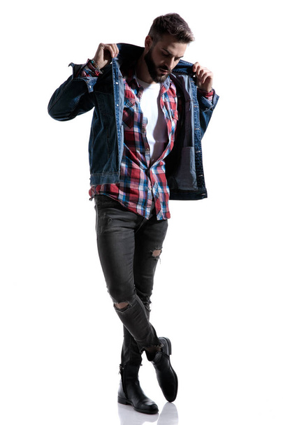 δραματικό νεαρό μοντέλο σε καρό πουκάμισο κρατώντας γιακά  - Φωτογραφία, εικόνα