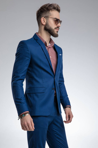 dramatic young model in blue suit wearing sunglasses - Photo, Image