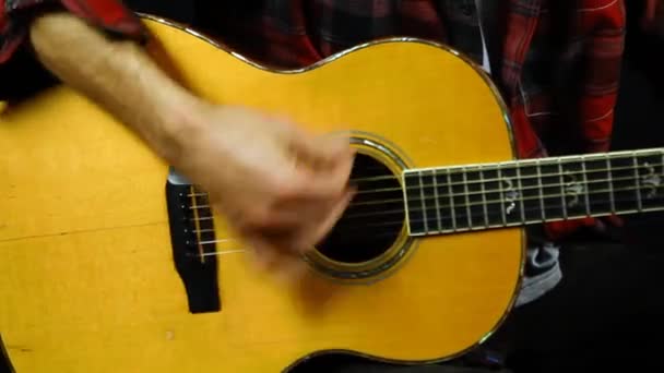 Ember szvingel egy akusztikus gitáron.  - Felvétel, videó
