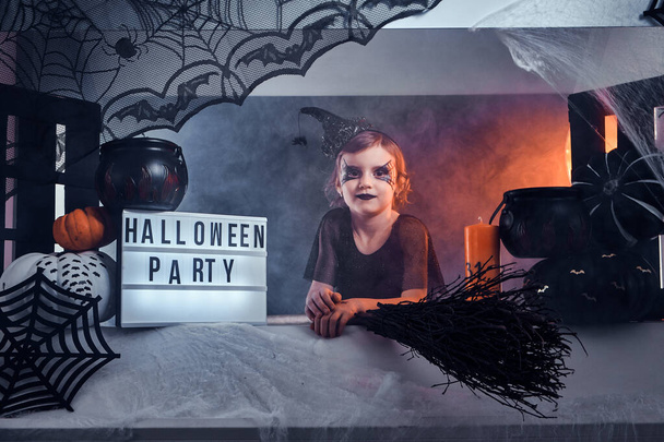 Porträt der coolen kleinen Hexe mit Halloween-Dekoration - Foto, Bild