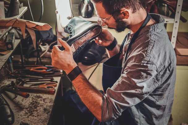 Cobbler is repairing shoes for customers - Foto, Bild