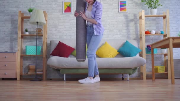 young woman brings a new carpet - Filmmaterial, Video